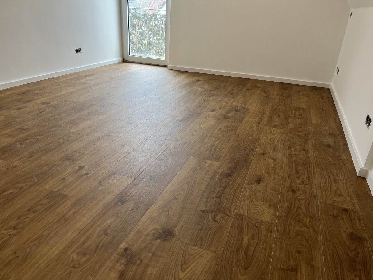 Heller Raum mit Holzboden und weiß gestrichenen Wänden